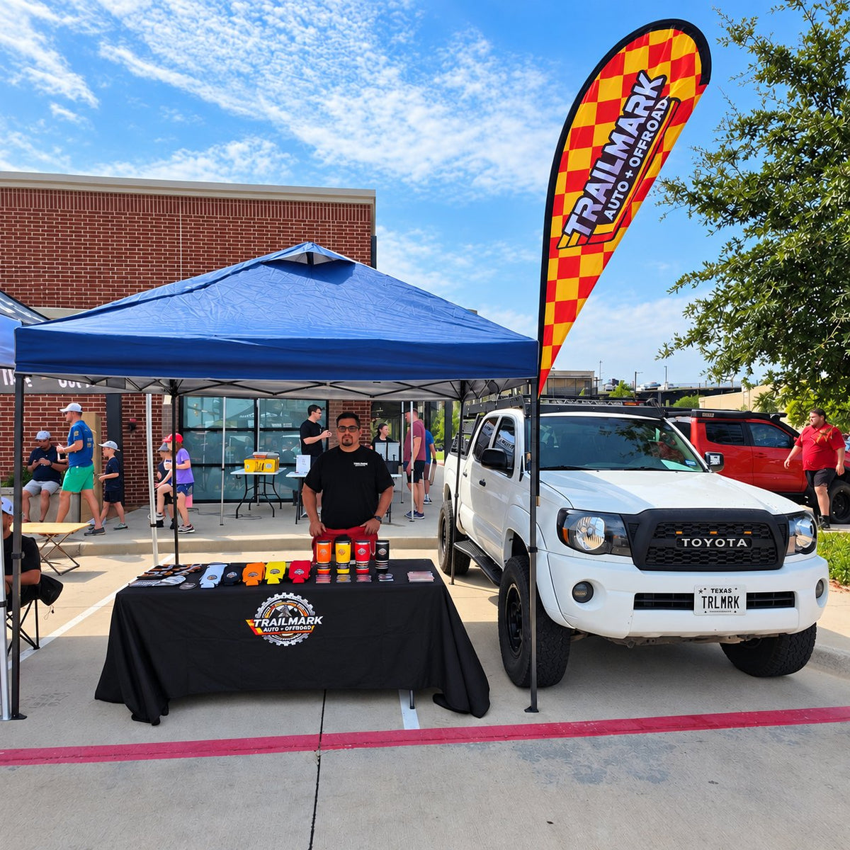 Trailmark booth at an event with a Trailmark Tacoma and feather flag